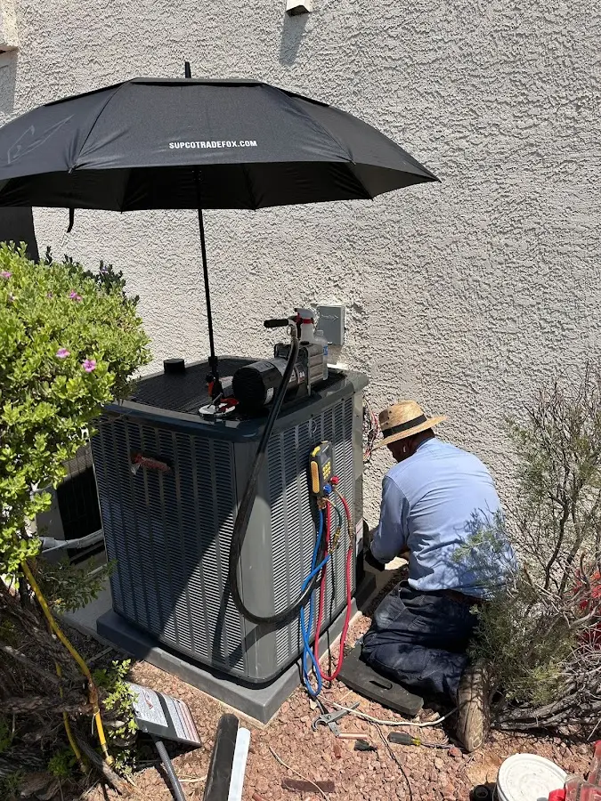 HVAC technician performing outdoor AC maintenance in The Acreage