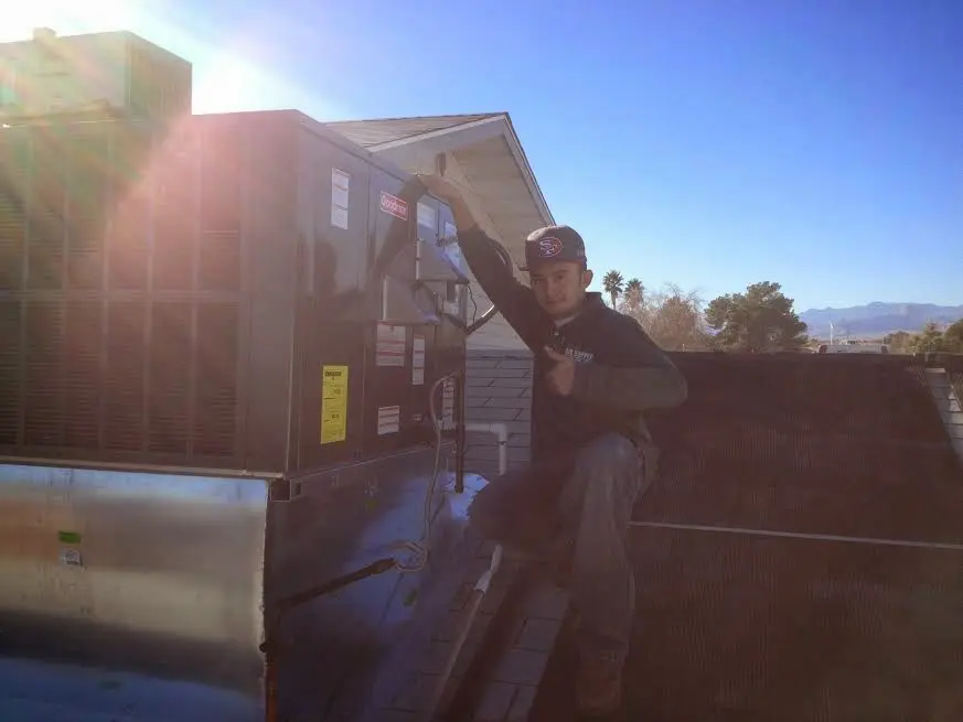 HVAC technician performing AC Tune-Up on a rooftop unit in The Acreage